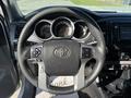 Steering wheel of a 2015 Toyota Tacoma with controls and dashboard gauges visible
