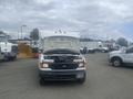 A 2004 Ford Econoline van with the hood raised revealing the engine compartment