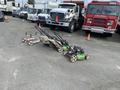 Three Honda Lawnboy mowers and two Stihl line trimmers are positioned in a row on a pavement surface
