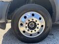 Close-up of the shiny chrome wheel of a 2016 Ford F-550 featuring multiple bolt holes and a Michelin tire with visible tread pattern