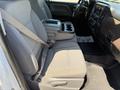Interior view of a 2016 GMC Sierra 1500 featuring two front seats with seat belts a center console with cup holders and a floor mat