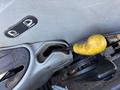 Close-up of the gear shift lever with a yellow grip on a 2010 New Holland T4050 tractor's interior console