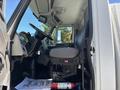 Interior view of a 2008 International DuraStar showing the driver's seat steering wheel and dashboard with a fire extinguisher on the floor and a thank you mat