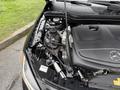 Close-up of the engine compartment of a 2016 Mercedes-Benz GLA-250 highlighting the black engine cover and various components including hoses and wiring