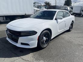 A white 2017 Dodge Charger with black wheels parked on a paved surface