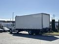 A 2015 Freightliner M2 106 truck with a large white box cargo area is parked, facing away from the viewer with its cab visible in the foreground