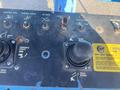 Controls and joystick for a 1997 Genie S-65 4X4 with various buttons for adjusting platform level, turntable rotation, boom movements, and engine start features