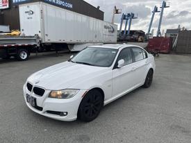 A white 2011 BMW 3-Series parked with black wheels and a sleek design