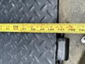 A close-up view of a measuring tape laid across the surface of a textured metal platform on a 2013 Kenworth T370