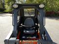 View of the operator's seat inside a 2017 Gehl R105 skid steer loader with control levers and safety features visible