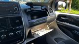 Interior view of a 2016 Dodge Grand Caravan highlighting the dashboard with controls and an open glove compartment