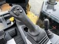 Close-up of the joystick control of a 2024 Caterpillar 306 featuring buttons for functions like throttle and auxiliary operations