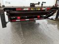 A 2006 GMC F7B042 truck with a rusted tailgate and visible brake lights positioned on a wet surface