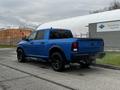 A blue 2021 RAM 1500 Classic with a black grille and wheels parked, showcasing its sleek design and robust build