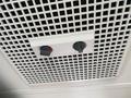 A ventilation grille with two adjustable knobs for temperature control mounted on a white ceiling panel