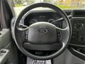 Steering wheel of a 2014 Ford Econoline with Ford logo and control buttons visible on the left and right