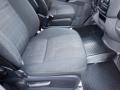 The interior of a 2016 Mercedes-Benz Sprinter featuring two front seats with fabric upholstery and a textured rubber floor mat