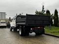 A 2005 GMC C5 Duramax flatbed truck with a black dump body facing slightly to the right