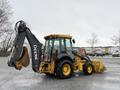2011 John Deere 310SJ 4x4 Wheel Loader with an extended hoe and a 4 in 1 bucket positioned for operation