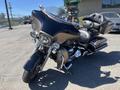 A 2004 Harley-Davidson FLHTCUI motorcycle with a large front fairing and a black leather seat positioned prominently at an angle