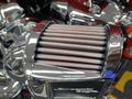 Close-up of a chrome air filter for a 2024 Harley Davidson Fat Boy featuring a ribbed design with a black label reading Screamin Eagle