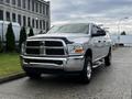 A silver 2012 RAM 3500 pickup truck with a chrome grille and black accents parked on a street