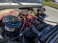 Close-up view of the engine compartment of a 2016 Freightliner M2 106 featuring various wires hoses and components including a prominent air filter and a red engine block