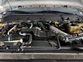 Engine compartment of a 2011 Ford F-450 SD showing various components such as hoses pipes and a large air intake system