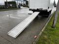 A white 2021 Mitsubishi FE truck with a ramp extended from the rear for loading and unloading cargo