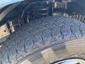Close-up of a tire from a 2008 Ford E-350 showing deep tread patterns on a rugged surface