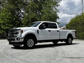 2020 Ford F-350 Super Duty in white with a crew cab and four-wheel drive visible side profile and chrome accents
