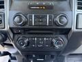 Dashboard controls of a 2018 Ford F-150 including audio buttons air conditioning settings and a screen with various function options