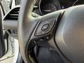 Close-up of the steering wheel controls of a 2021 Toyota C-HR featuring buttons for audio control and phone functions