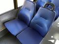 A pair of blue, padded seats with textured surfaces in a public transport vehicle