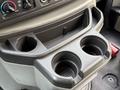 A console storage area with two cup holders and a compartment for small items in a 2009 Ford Econoline