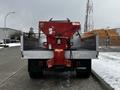 A red 2008 Ford F-450 SD with a salt spreader attached to the truck bed parked on a snowy road