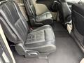 Interior view of a 2017 Dodge Grand Caravan featuring two black leather seats with armrests and a spacious area between them