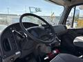 Interior view of a 2015 Freightliner M2 106 featuring a steering wheel dashboard and controls with a fire extinguisher visible on the floor