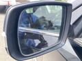 A side mirror of a 2015 Kia Sorento showing a reflection of a person holding a device