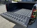 A 2019 RAM 1500 truck with an open tailgate revealing a textured bed liner inside the truck bed