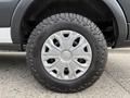 A close-up of a silver alloy wheel with distinctive multi-spoke design mounted on an all-terrain tire labeled with "LT245/75R16"