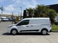 A 2021 Ford Transit Connect van in white with a sliding side door and black trim parked in a lot
