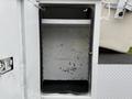 A white storage compartment with a black floor and a single shelf inside, designed for use on a 2012 Ford F-450 SD truck