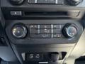 Dashboard controls of a 2015 Ford F-150 featuring climate control knobs and buttons for air conditioning and airflow settings