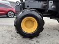 A close-up of a yellow and black tire from a 1994 John Deere F1145 tractor with chunky tread design