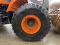 Close-up of a large, rugged tire from a 2018 Doosan DL300-5 with a bold orange rim and deep treads designed for traction and stability