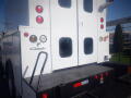 A 2005 Ford F-750 truck with a white exterior featuring rear doors and various lights on the back panel