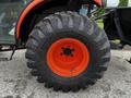 A close-up of a rugged tire mounted on a Kubota B2650 tractor featuring a bright orange rim and deep treads for traction