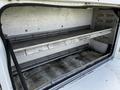 Interior of a 2008 Ford F-550 service body with metal shelves and storage space visible inside the compartment