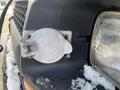 Close-up of the fuel cap on a 2005 Chevrolet Express with snow on the surface and a branding label visible on the cap